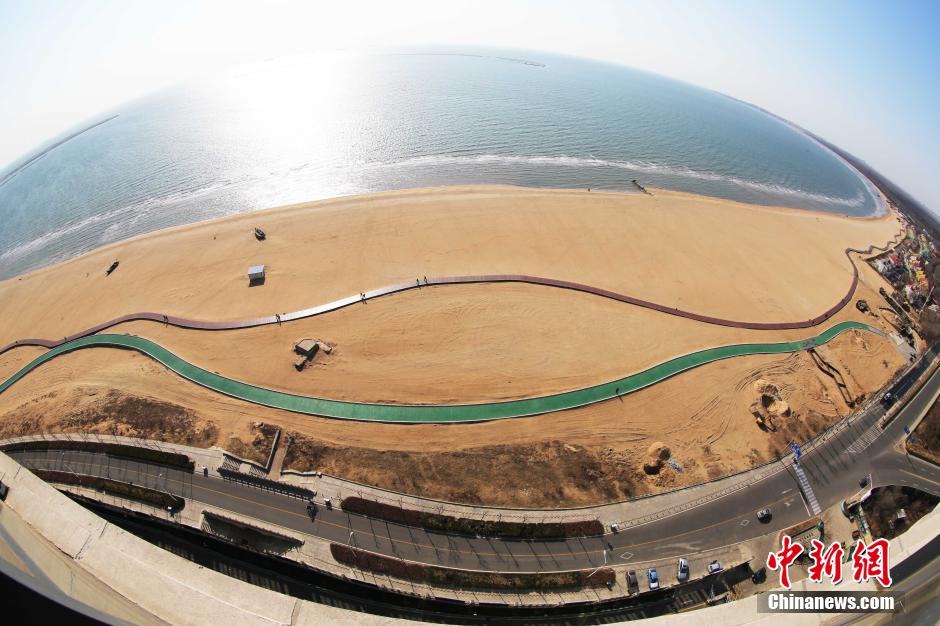 3月13日，秦皇島萬米臨海沙灘木棧道。據(jù)了解，該木棧道全長(zhǎng)約4200米，與北戴河區(qū)原有的7500米木棧道對(duì)接后全線總長(zhǎng)度1.17萬米，整個(gè)木棧道東起秦皇島體育基地游船碼頭，西至北戴河濕地公園，呈波浪形蜿蜒10.4公里海岸線。 中新社發(fā) 曹建雄 攝 CNSPHOTO